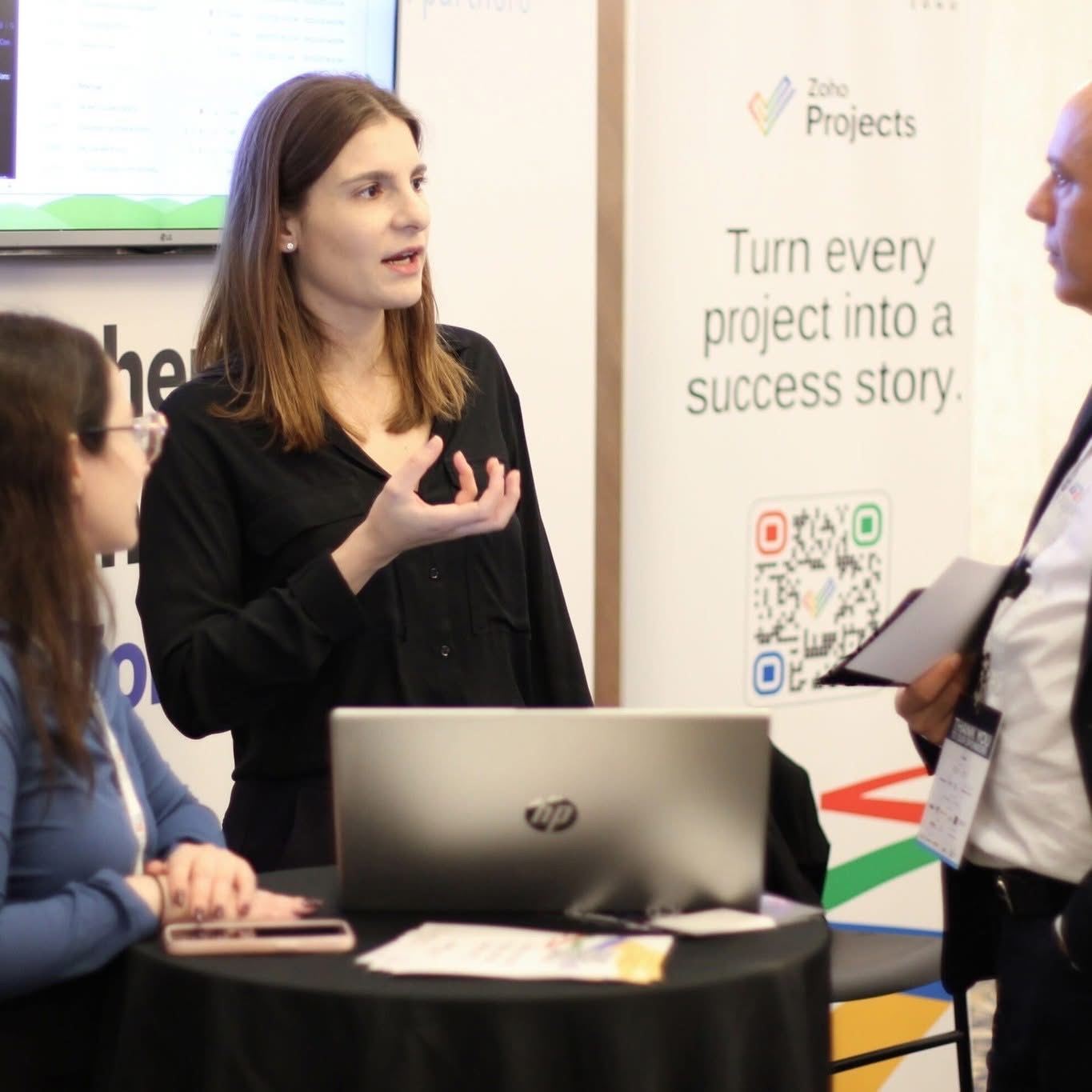 Capacitor Partners speaking with delegates at the Zoho Projects stand during the conference